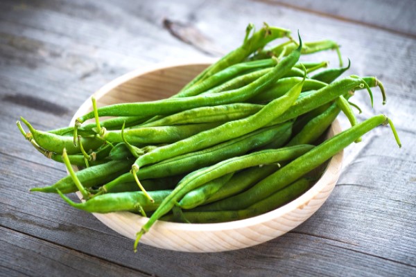 Wooden bowl filled with fresh green beans