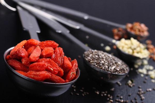 Set of tablespoons and teaspoons holding goji berries, chia seeds, and other foods
