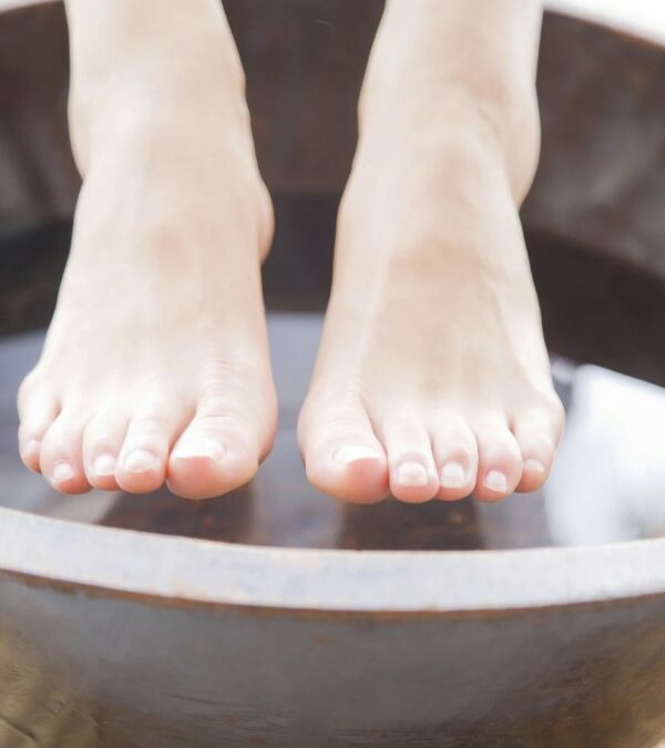 Pair of feet going to soak in a basic of warm water